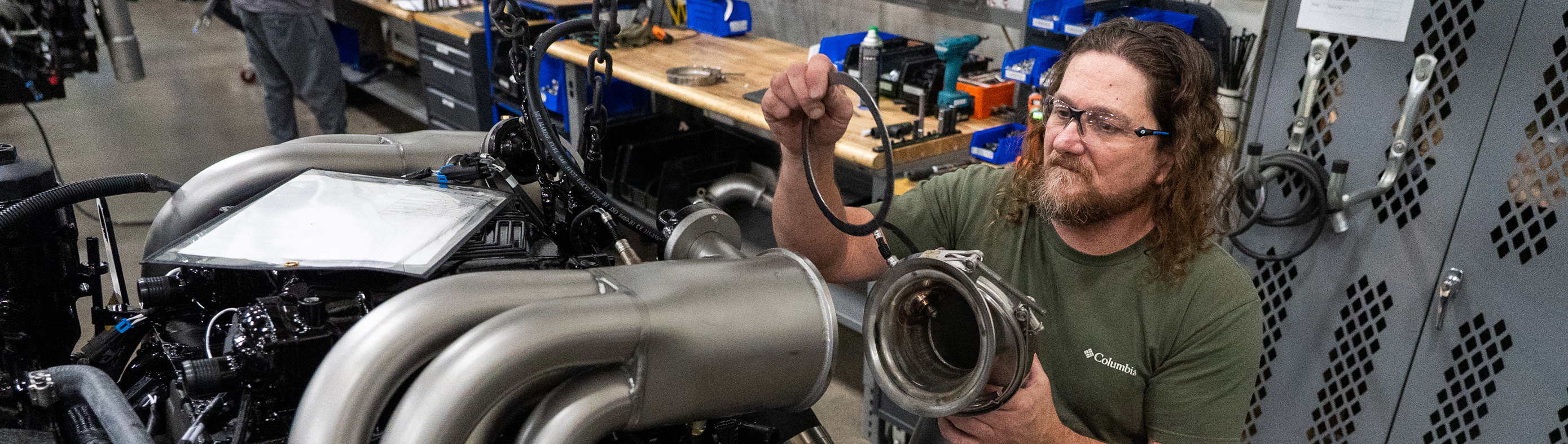 Man assembling boat engine parts at Marine Components.